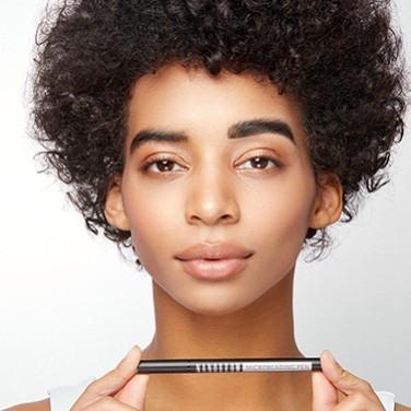 Modelo negro sosteniendo el Microblading Pen horizontalmente