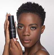 Modelo negra con pelo corto sosteniendo el champú Lash & Brow